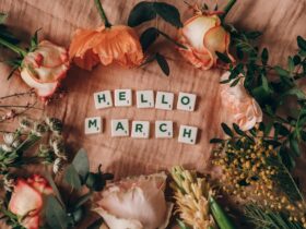 scrabble tiles on pink surface near flowers